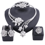 Enhance your wedding day style with this elegant jewelry set, consisting of a gold-colored crystal rose flower necklace, earrings, ring, and bangle, ideal for bridal accessories.