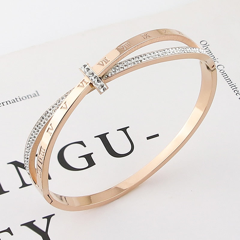 Shapely letters adorn this stainless steel bangle, a timeless accessory that flatters all outfits! The perfect complement to every wardrobe, this fashionable bangle is sure to make a statement.