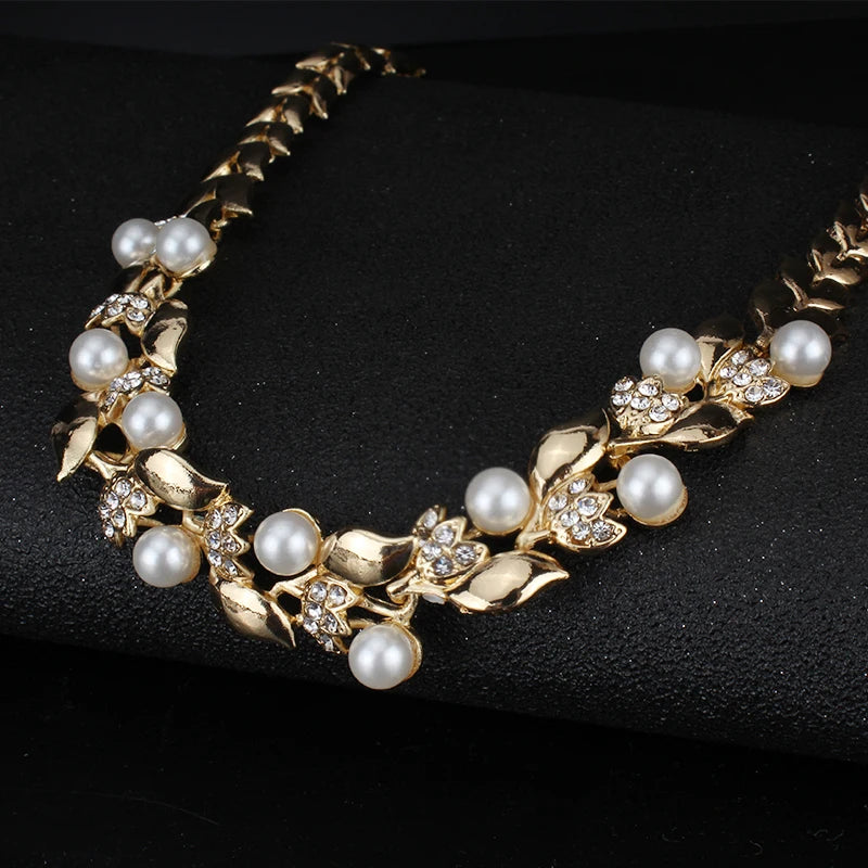 Enhance your wedding attire with this exquisite set of Dubai wedding jewelry. The set includes a stunning imitation pearl necklace and earrings, designed to complement women's dresses in gold colors. These accessories will add a touch of elegance and sophistication to your overall look.