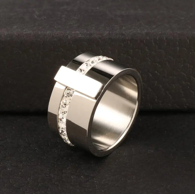 Elevate your style with our exquisite collection of wide rings for women. Crafted from high-quality stainless steel, these silver-colored rings feature a single row of sparkling cubic zirconia, adding a touch of luxury to any outfit. Perfect for wedding bands or everyday wear, these rings are designed to make a statement and enhance your femininity. Explore our range and find the perfect ring for you.