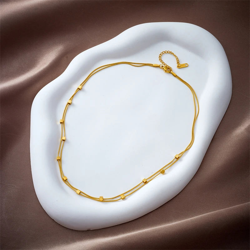 This necklace is made of 316L stainless steel and features a 2-in-1 design with small cube chains. It is available in gold and silver colors, making it a stylish accessory for women. This choker necklace is perfect for parties and also makes a great jewelry gift for girls.