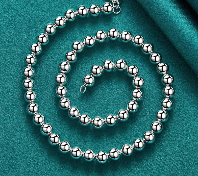 This set of jewelry includes a bracelet, necklace, and earrings made of 925 sterling silver. The beads are hollow and have a diameter of 8mm. It is designed for women and can be worn for various occasions such as weddings, engagements, or as a charm jewelry.