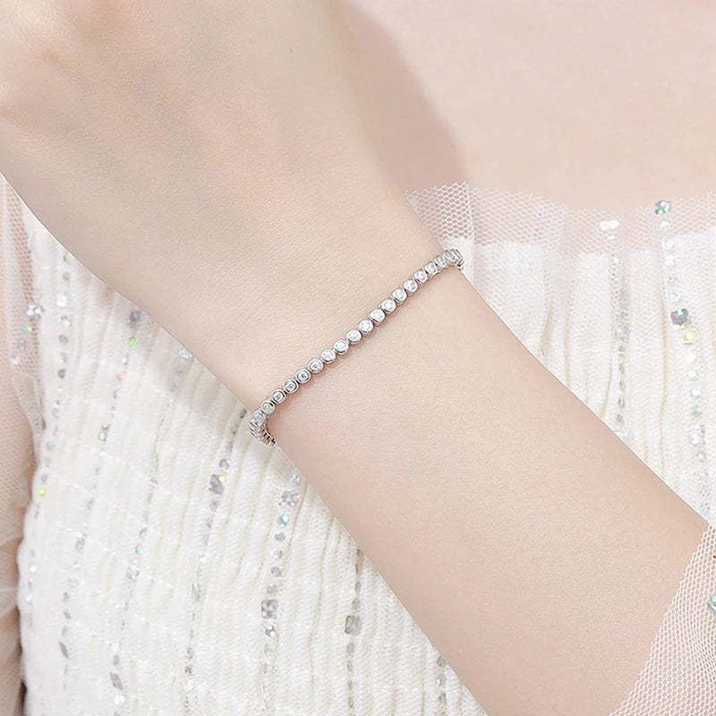 This bracelet is a stylish accessory suitable for both women and men. It features a tennis design and is made with GRA 100% Sterling Silver, which is then plated with 18k White Gold for an elegant touch.