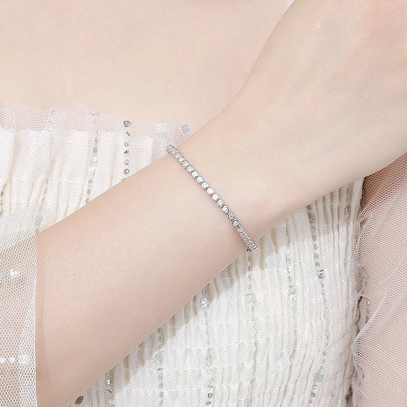 This bracelet is a stylish accessory suitable for both women and men. It features a tennis design and is made with GRA 100% Sterling Silver, which is then plated with 18k White Gold for an elegant touch.
