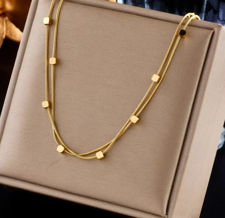 This necklace is made of 316L stainless steel and features a 2-in-1 design with small cube chains. It is available in gold and silver colors, making it a stylish accessory for women. This choker necklace is perfect for parties and also makes a great jewelry gift for girls.