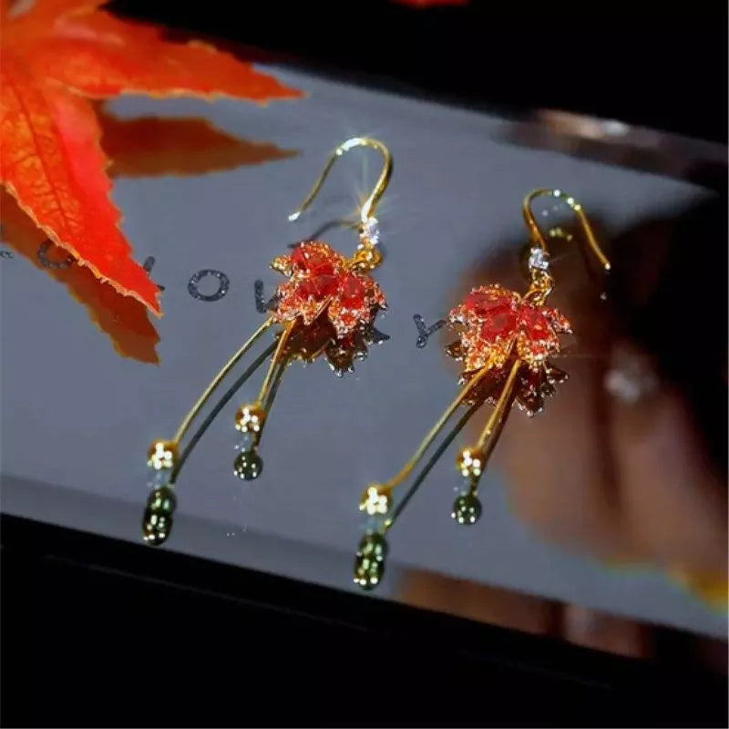 The allure of these exquisite French vintage earrings adorned with red maple leaf crystals and zircon stones. These elegant tassel earrings are designed to enhance a woman's temperament and add a touch of glamour to any party ensemble. They make a perfect gift for someone special who appreciates fine jewelry.