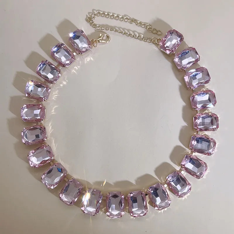 Elevate your style with this exquisite piece of jewelry - a luxurious, classic, and shiny pink champagne crystal necklace. The adjustable square pendant, adorned with a large glass centerpiece, adds a touch of elegance to your clavicle chain. Embrace the fashion-forward design and make a statement with this stunning fashion accessory.