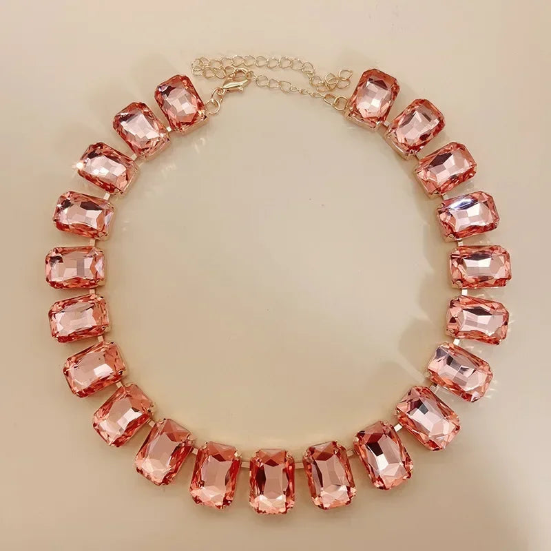 Elevate your style with this exquisite piece of jewelry - a luxurious, classic, and shiny pink champagne crystal necklace. The adjustable square pendant, adorned with a large glass centerpiece, adds a touch of elegance to your clavicle chain. Embrace the fashion-forward design and make a statement with this stunning fashion accessory.