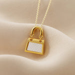  This exquisite necklace features a square bag pendant made of white shell, set in 18k gold (au750). It is a fashionable and personalized piece of jewelry, perfect for women to wear on special occasions like weddings or anniversaries. It also makes a great gift choice for such occasions.