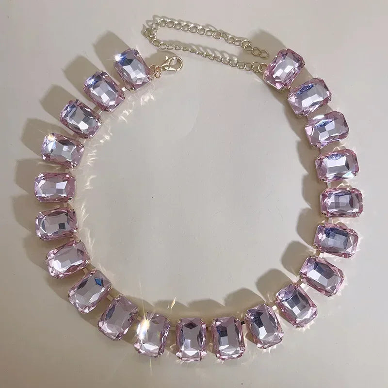 Elevate your style with this exquisite piece of jewelry - a luxurious, classic, and shiny pink champagne crystal necklace. The adjustable square pendant, adorned with a large glass centerpiece, adds a touch of elegance to your clavicle chain. Embrace the fashion-forward design and make a statement with this stunning fashion accessory.