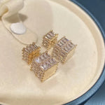 The exquisite earrings adorned with dazzling zircon gemstones, radiating elegance and sophistication. These square golden earrings are a symbol of luxury and make for the perfect Christmas gift for women, adding a touch of cuteness to any outfit.