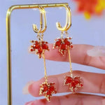 The allure of these exquisite French vintage earrings adorned with red maple leaf crystals and zircon stones. These elegant tassel earrings are designed to enhance a woman's temperament and add a touch of glamour to any party ensemble. They make a perfect gift for someone special who appreciates fine jewelry.